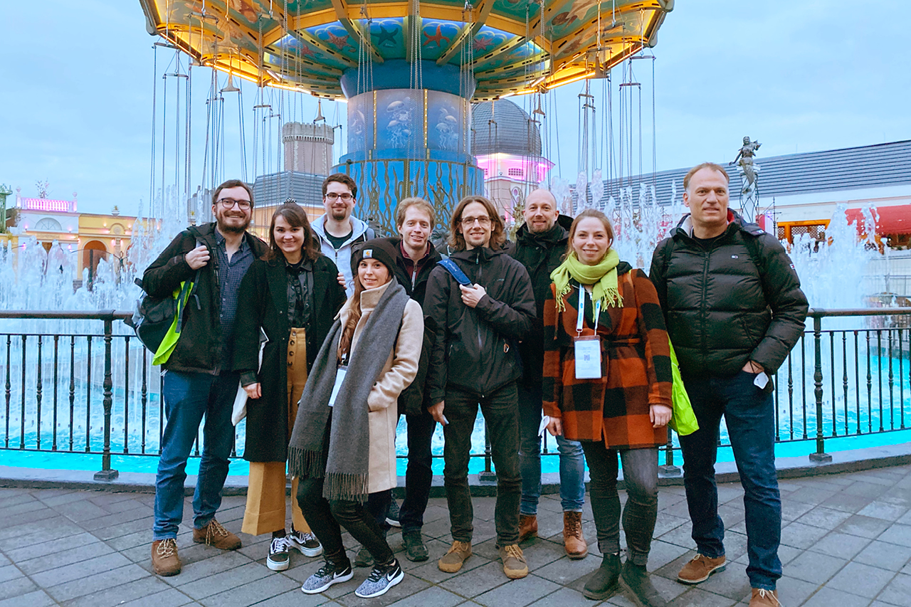 Gruppenfoto von cronn-Mitarbeiter:innen auf der JavaLand vor einem Kettenkarussell.